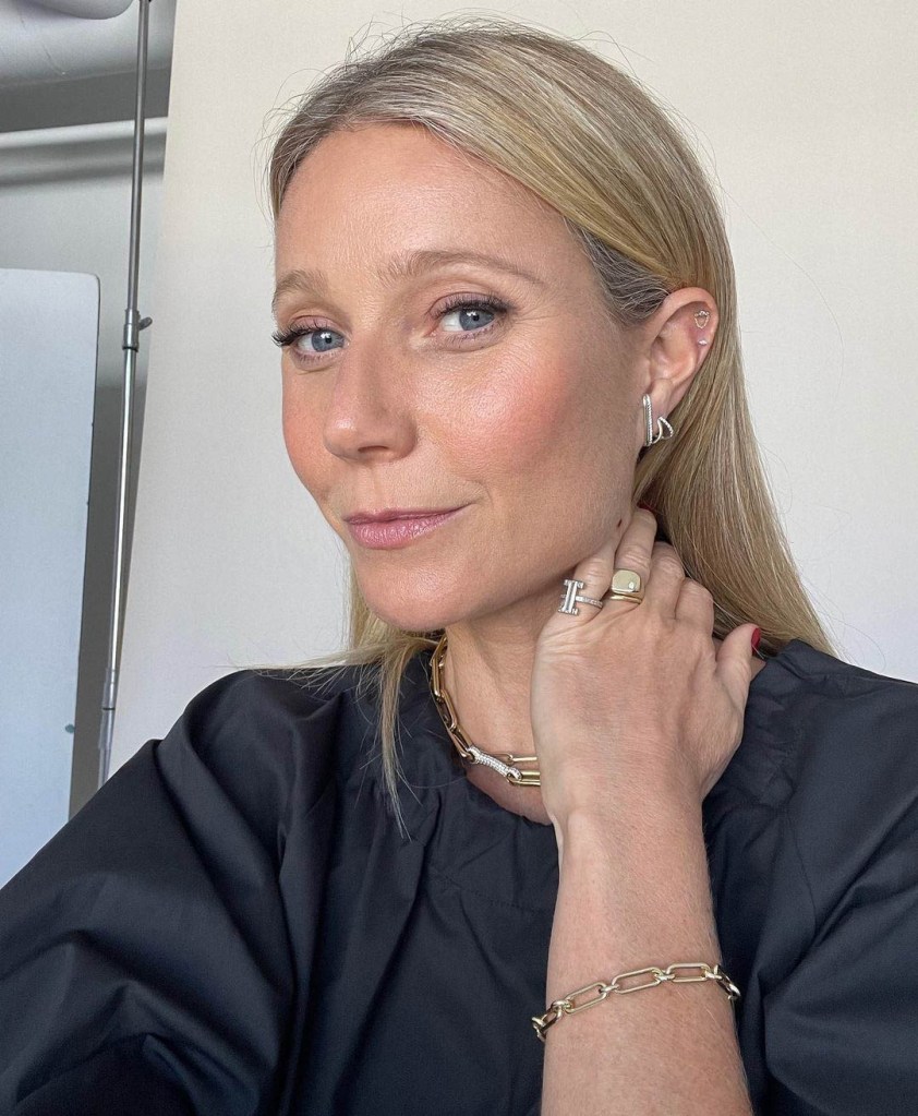 Gwyneth Paltrow wearing a black shirt and gold jewelry.