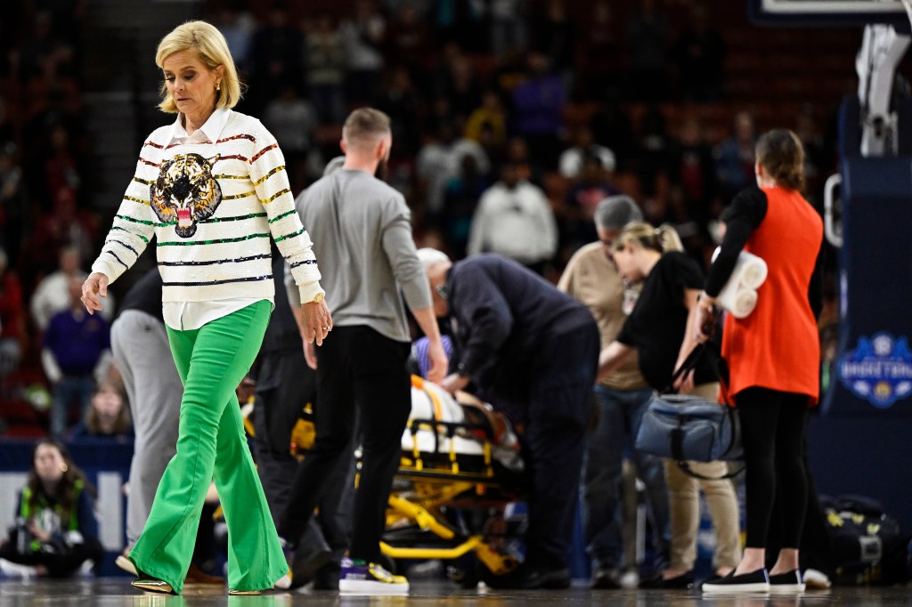 LSU head coach Kim Mulkey (l.) walks off the court as Last-Tear Poa is taken off on a stretcher.