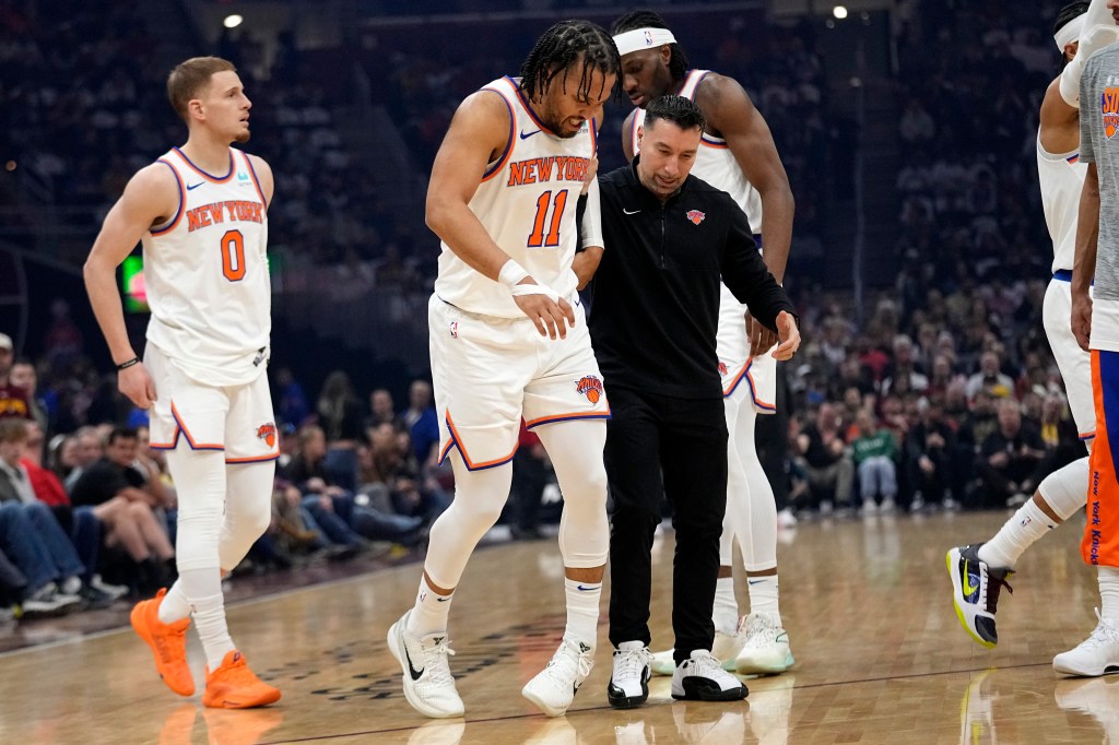 Knicks guard Jalen Brunson (11) is helped off the court after an injury in the first half of an NBA basketball game against the Cleveland Cavaliers.