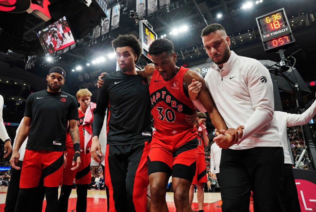 Raptors guard Ochai Agbaji (30) is helped off the court after an injury during the first half