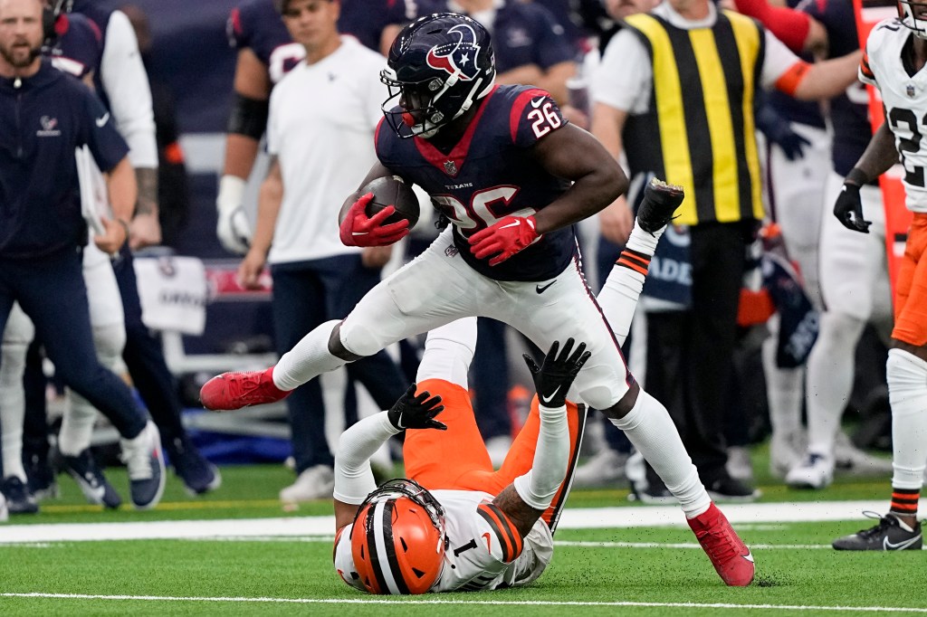 Devin Singletary rushing past Juan Thornhill in a Browns Texans football game, Jan 13th, 2024