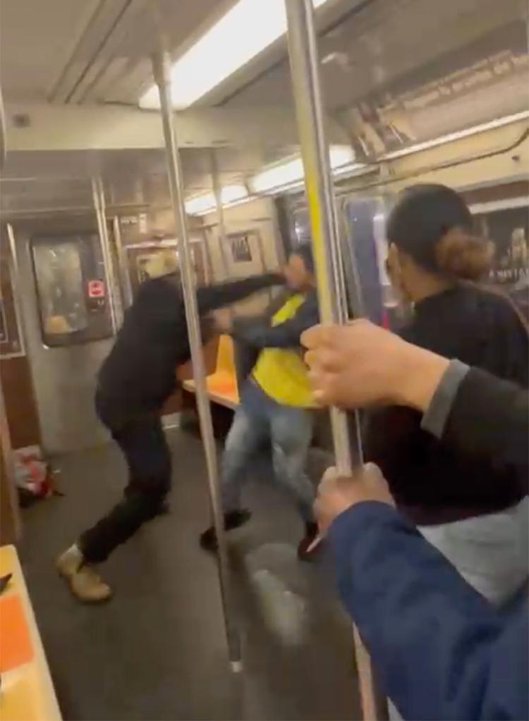 A photo of two men sparring on a NYC subway train