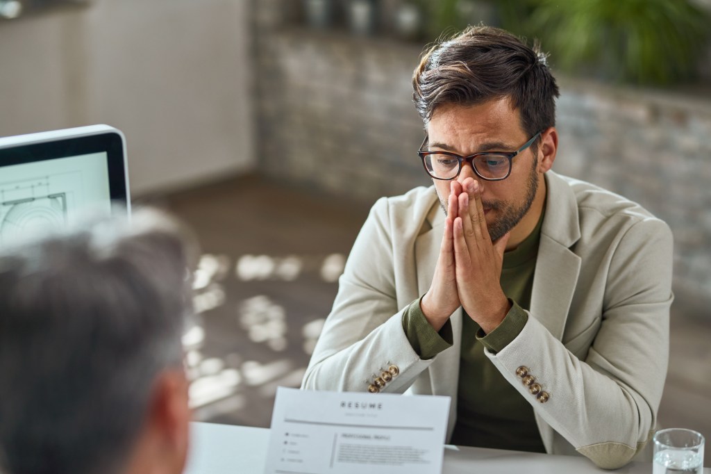 Distraught young man feeling uncertain while having a job interview in the office.