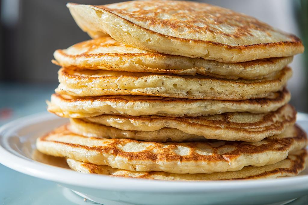 Macro closeup side view of stack of buttermilk pancakes on plate.