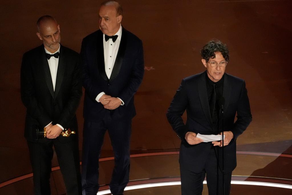 James Wilson, from left, Leonard Blavatnik, and Jonathan Glazer accept the award for "The Zone of Interest" from the United Kingdom, 