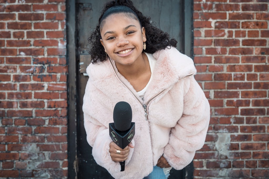 Jazlyn 'Jazzy' Guerra, a 13-year-old YouTube reporter and influencer, holding a microphone in Maria Hernandez Park, Bushwick, Brooklyn, NY