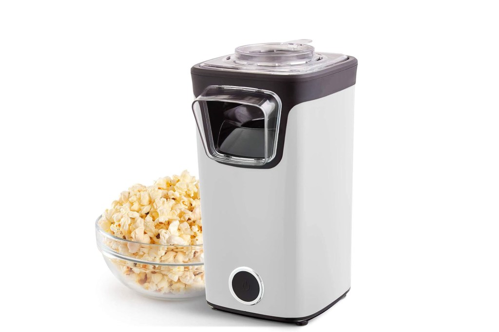 Popcorn machine next to a bowl of popcorn.