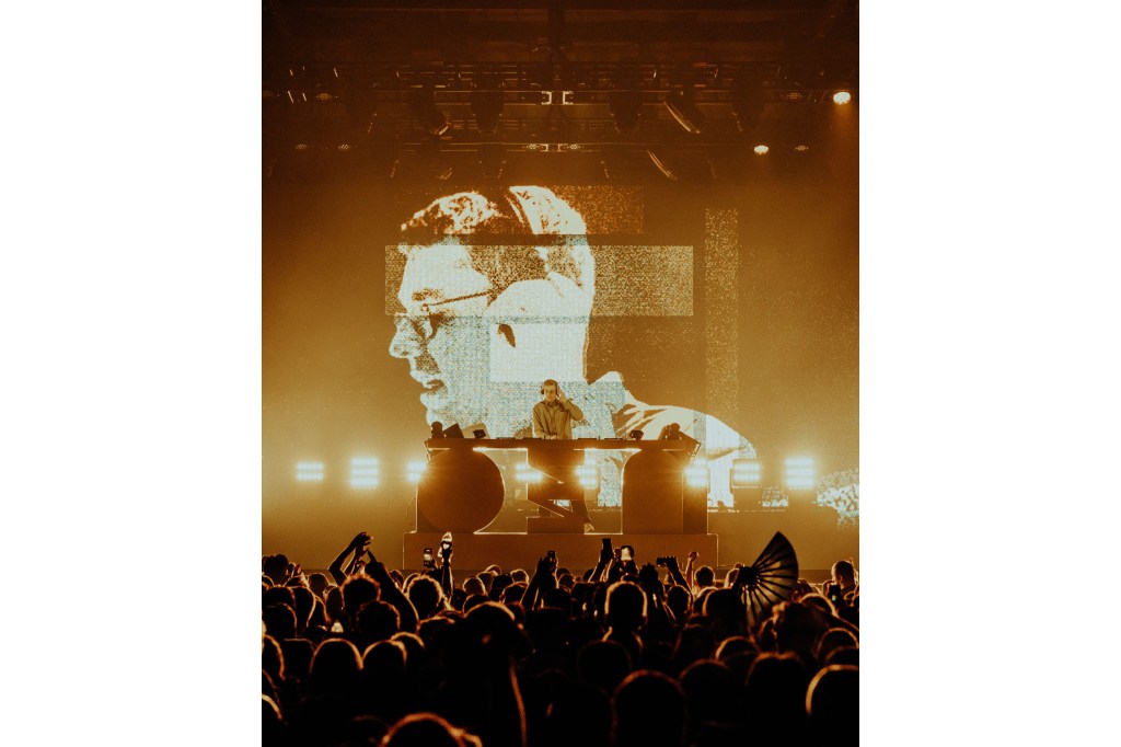 A man on a stage with a large crowd watching