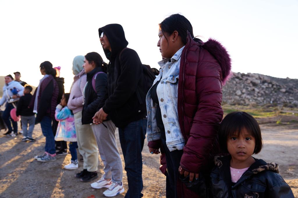 Lucia, 2nd from right, and her daughter Carla, 3, of Acapulco, Mexico, were found by a passing motorist in a mountain pass, after they crossed the U.S.-Mexico border wall gather and transported them to an encampment before they are processed and transported by U.S. Customs and Border Protection officers on Sunday, February 3, 2024 in Jacumba, Calif. 