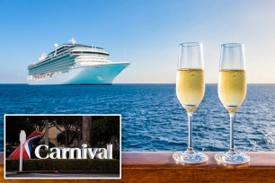 Two glasses of champagne placed on a railing overlooking a cruise ship at sunset