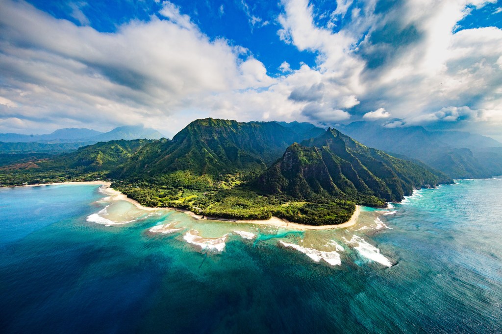 Na Pali Coast, Kauai" - An image of the Na Pali Coast in Kauai, featuring a beautiful shoreline surrounded by ocean water.
