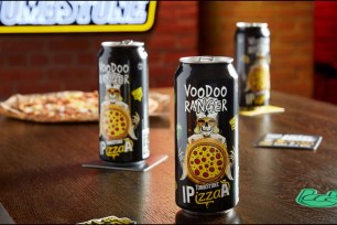 A group of black cans from New Belgium Brewing Co. and Tombstone frozen pizza's collaboration IPA, with "P" standing for pizza, on a table.