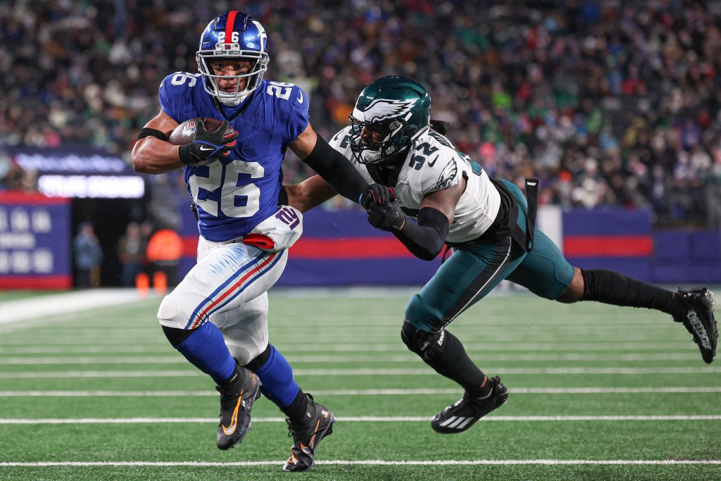 Saquon Barkley (#26) rushes for a touchdown, breaking a tackle by Zach Cunningham (#52) during a NFL game between the Eagles and Giants.