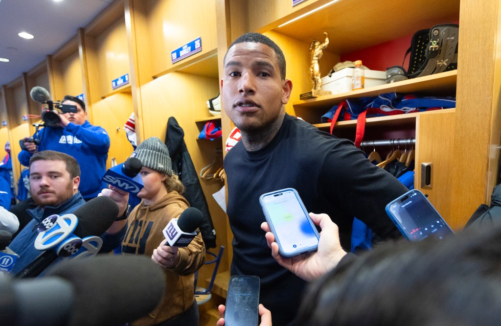 Darren Waller speaking to media with microphones in hand at the New York Giants training facility.