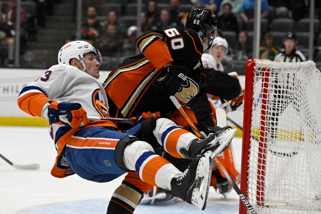 Islanders center Casey Cizikas, left, is upended next to Anaheim Ducks defenseman Jackson LaCombe (60) during the first period.