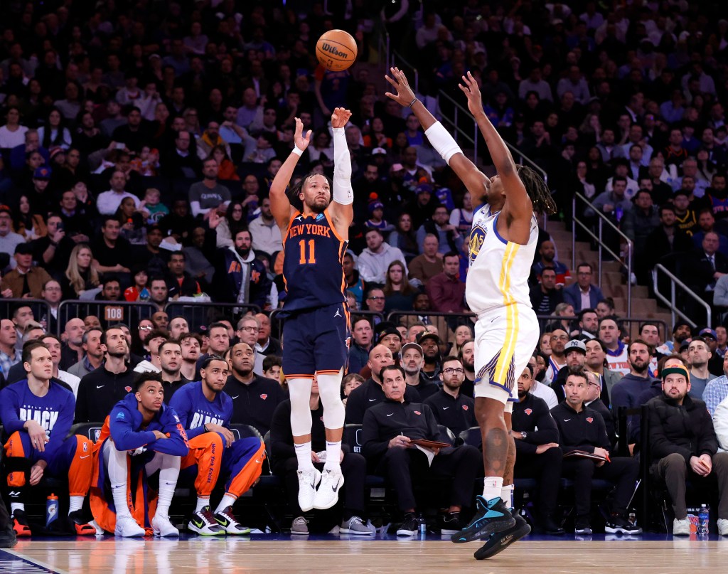 New York Knicks guard Jalen Brunson goes up for a shot as Golden State Warriors forward Kevon Looney  defends during the third quarter. 