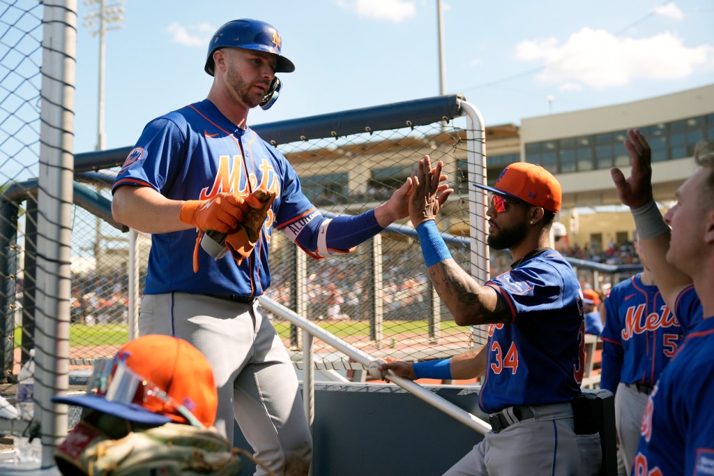 Mets' Pete Alonso is congratulated by teammates after hitting a ground-rule double during the fifth inning of a spring training baseball game