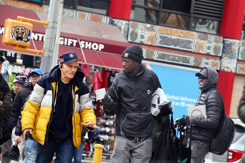 A photo of a peddler trying to sell a pedestrian.