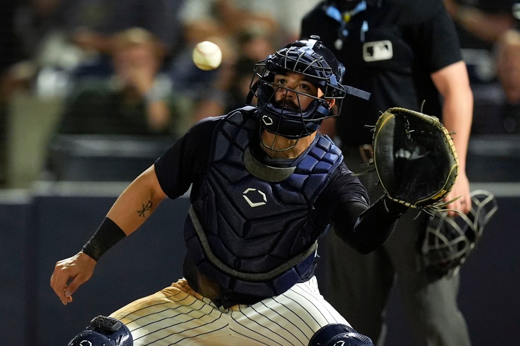 Austin Wells catches a ball at home plate during the second inning of a spring training baseball game against the Detroit Tigers.