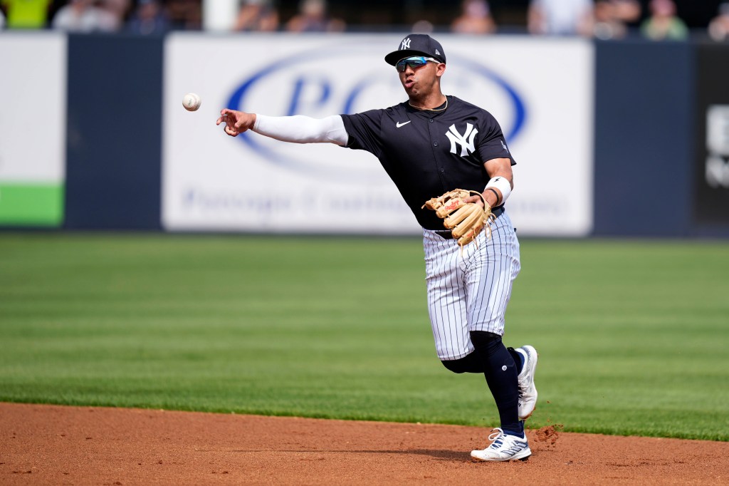 Oswald Peraza throws to first base during the first inning of a spring training baseball game against the Tampa Bay Rays.