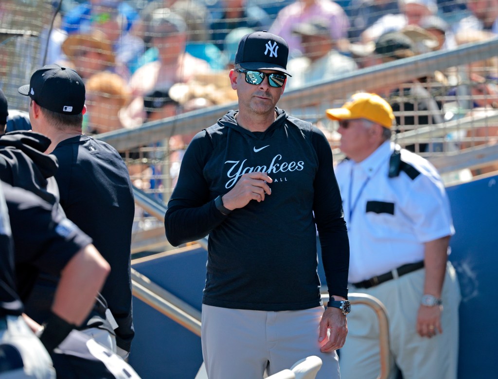 New York Yankees manager Aaron Boone, wearing a hat and sunglasses, in the dugout during a game against the Tampa Bay Rays at Charlotte Sports Park.