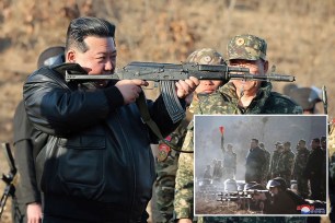 Kim Jong Un visiting a military base with soldiers standing on either side of him.