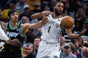 Mikal Bridges (right) and Andrew Nembhard battle for a loose ball during the Nets' 121-100 loss to the Pacers.