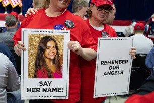 People holding posters with slain Georgia nursing student Laken Riley's photo at a Trump rally in Rome, Georgia on March 9, 2024.