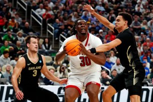 DJ Burns, who scored 24 points and grabbed 11 rebounds, goes up for a shot as Jack Gohlke (left) and Chris Conway defend during North Carolina State's 79-73 OT win over Oakland in the second round of the NCAA Tournament.