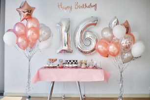 Table with balloons and sign on it.