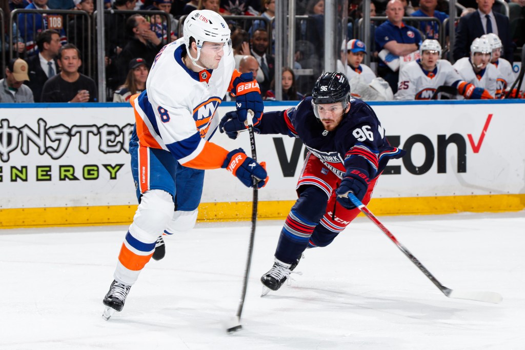 Noah Dobson #8 of the New York Islanders skates with the puck against Jack Roslovic #96 of the New York Rangers at Madison Square Garden.