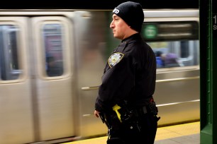 An NYPD Officer is seen at the platform at 116th Street and Lexington Avenue Subway station in New York City.