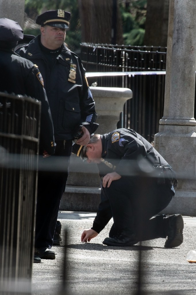 An NYPD sergeant examines a shell casing.