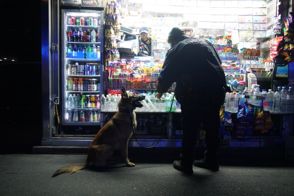 Officer Tulio Camejo and K9 King stop for water at a news stand