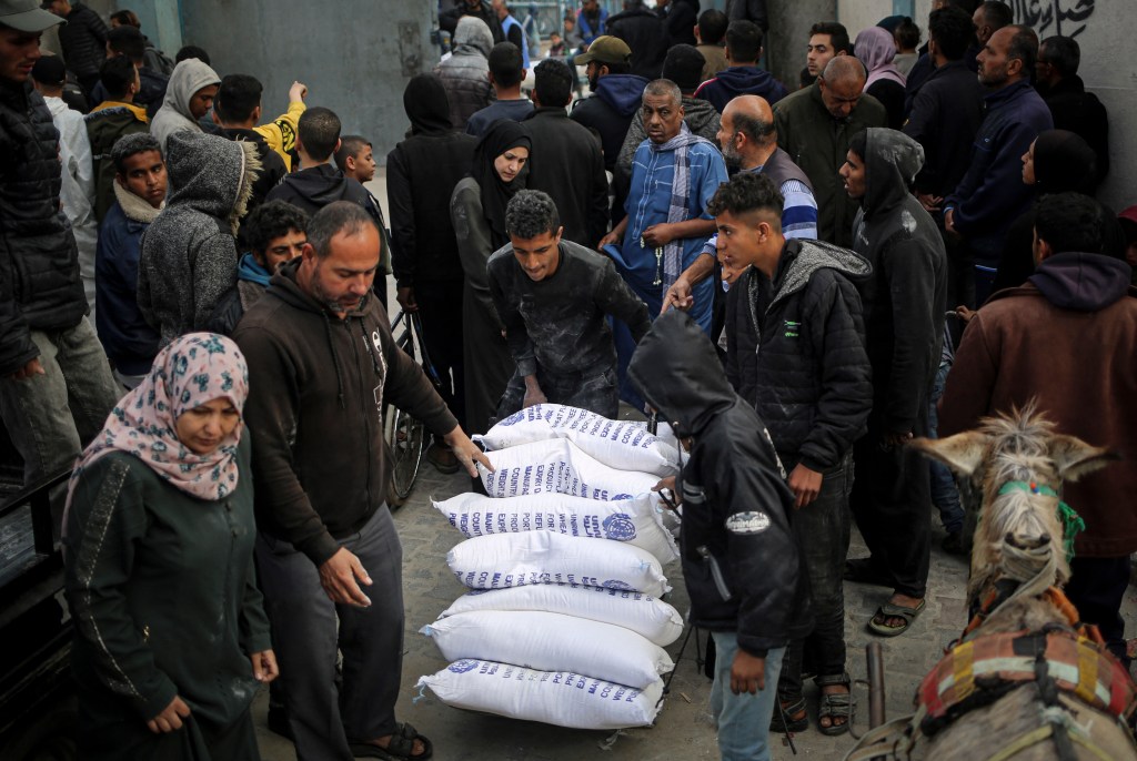 A Palestinian man delivering humanitarian aid at a UNRWA distribution center in Rafah.