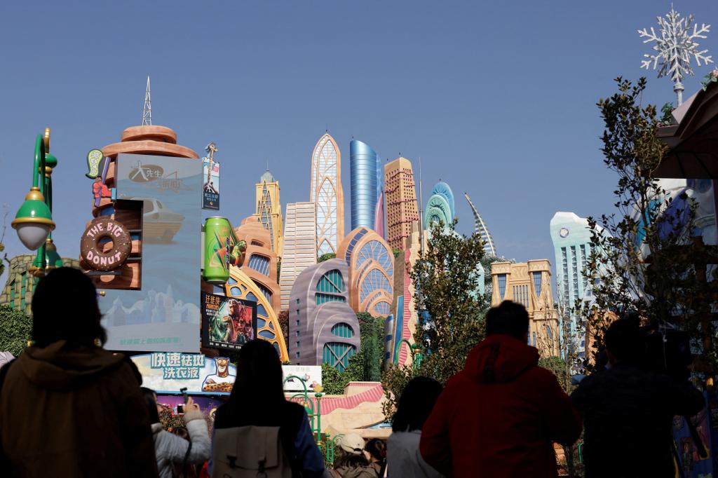 People attending media preview tour of Disney World's Zootopia-themed land attraction in front of a large building in Shanghai.