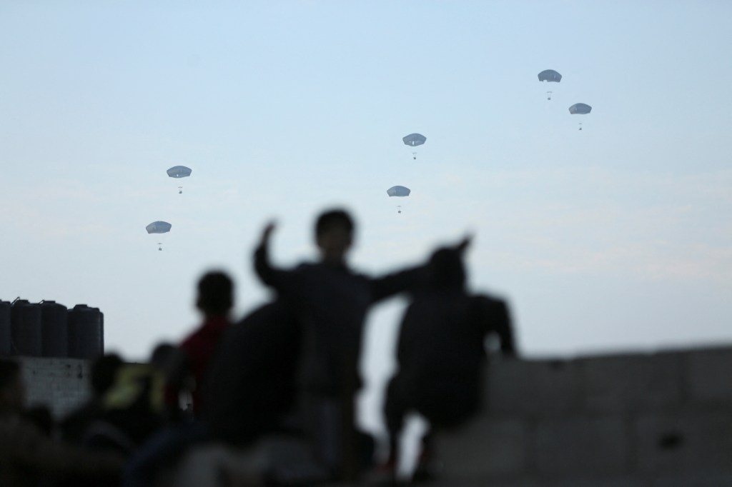 People watch as U.S. military carries out its first aid drop over Gaza, amid the ongoing the conflict between Israel and the Palestinian Islamist group Hamas, in Gaza City, March 2, 2024. REUTERS/Kosay Al Nemer
