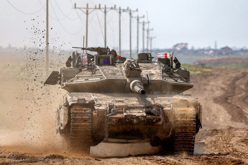 a military tank driving on dirt