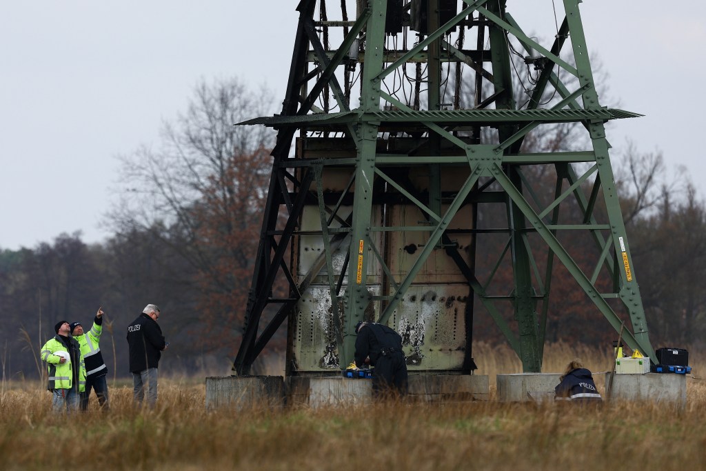 Police near the damaged pylon after the Tesla near Berlin halted production and was left without power.