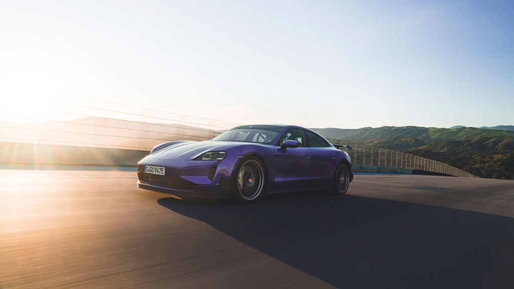 Purple Porsche Taycan Turbo GT driving on a road.