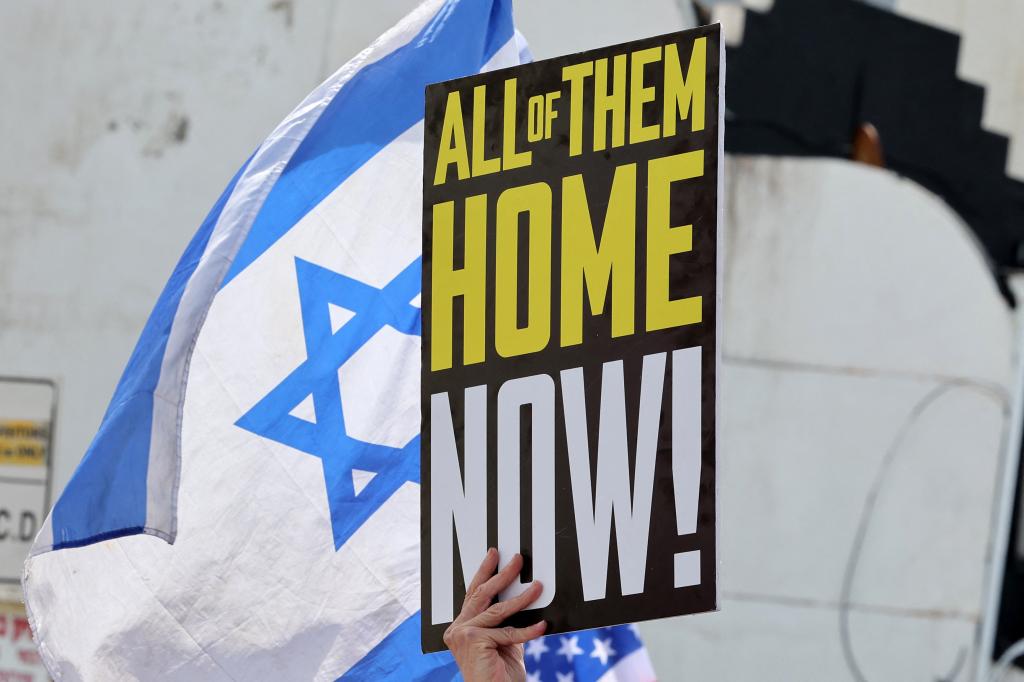 A protester holds a placard calling for the release of Israeli hostages in front of the US embassy in Tel Aviv, Israel