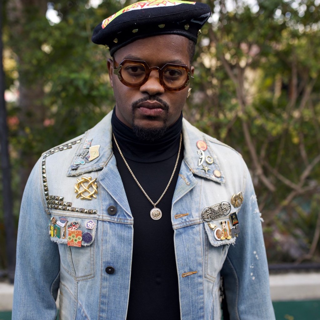 Rodney Jones dressed in a denim jacket and wearing big black glasses, staring at the camera.