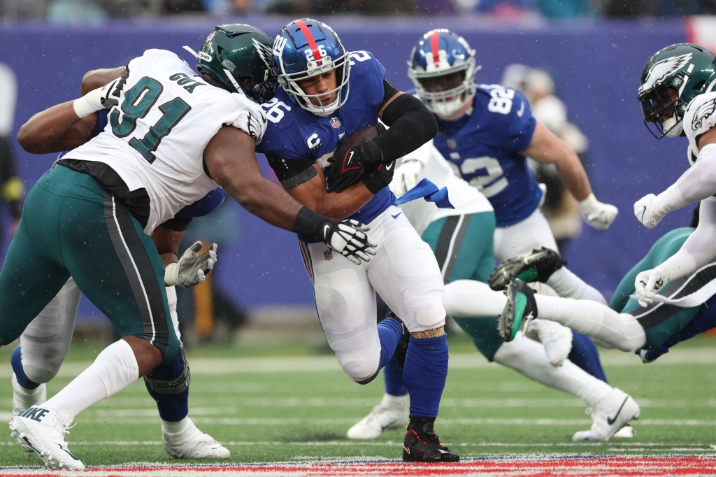 Saquon Barkley #26 of the New York Giants runs the ball against Fletcher Cox #91 of the Philadelphia Eagles during the second half at MetLife Stadium.