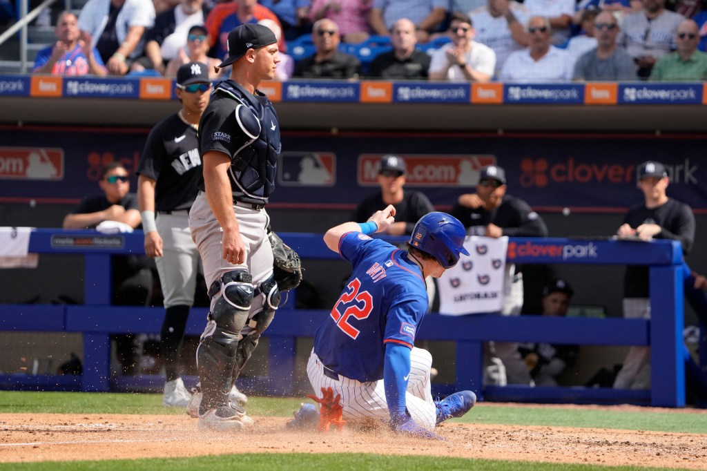 New York Mets' Brett Baty (22) scores past New York Yankees catcher Ben Rortvedt during the third inning of a spring training baseball game Tuesday, March 5, 2024, in Port St. Lucie, Fla.