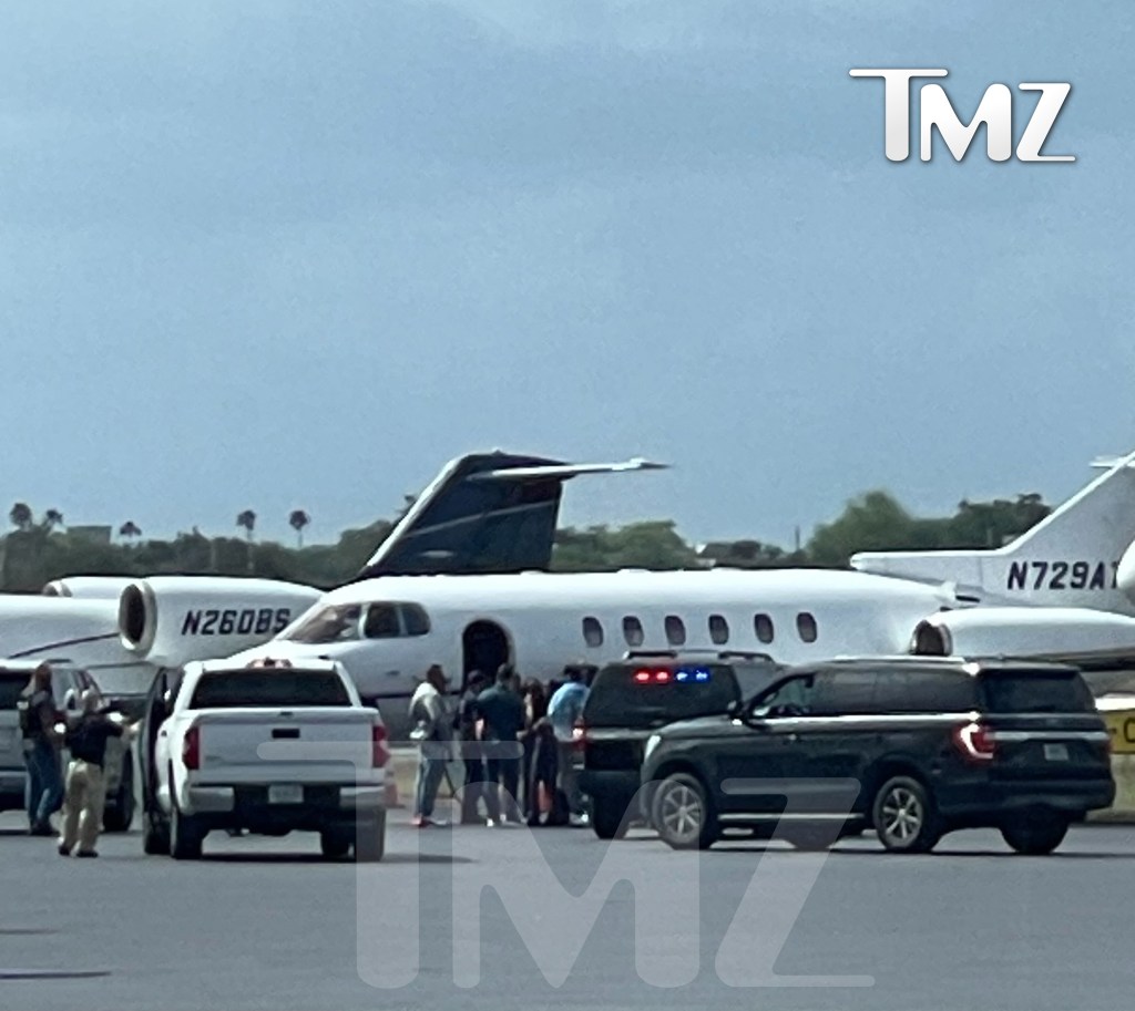 The rapper, 54, stood with his entourage as they were surrounded by a team of law enforcement officials at Miami-Opa Locka Executive Airport.