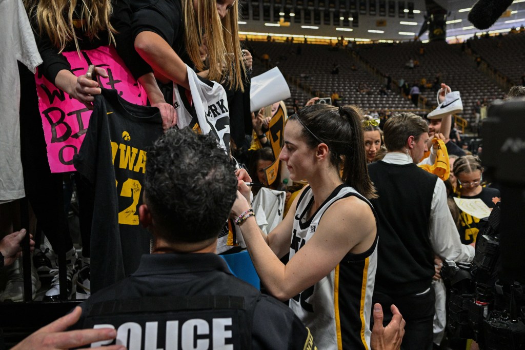 Caitlin Clark (22) signs autographs for fans after the victory against the Ohio State Buckeyes. 