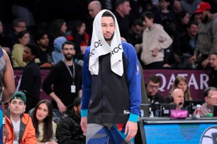 Ben Simmons #10 of the Brooklyn Nets with a towel on his head as he stands on the sideline during the second quarter.