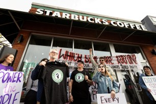 Singer Billy Bragg receives a Starbucks Workers United shirt from striking union members outside a Starbucks location in Buffalo, New York.