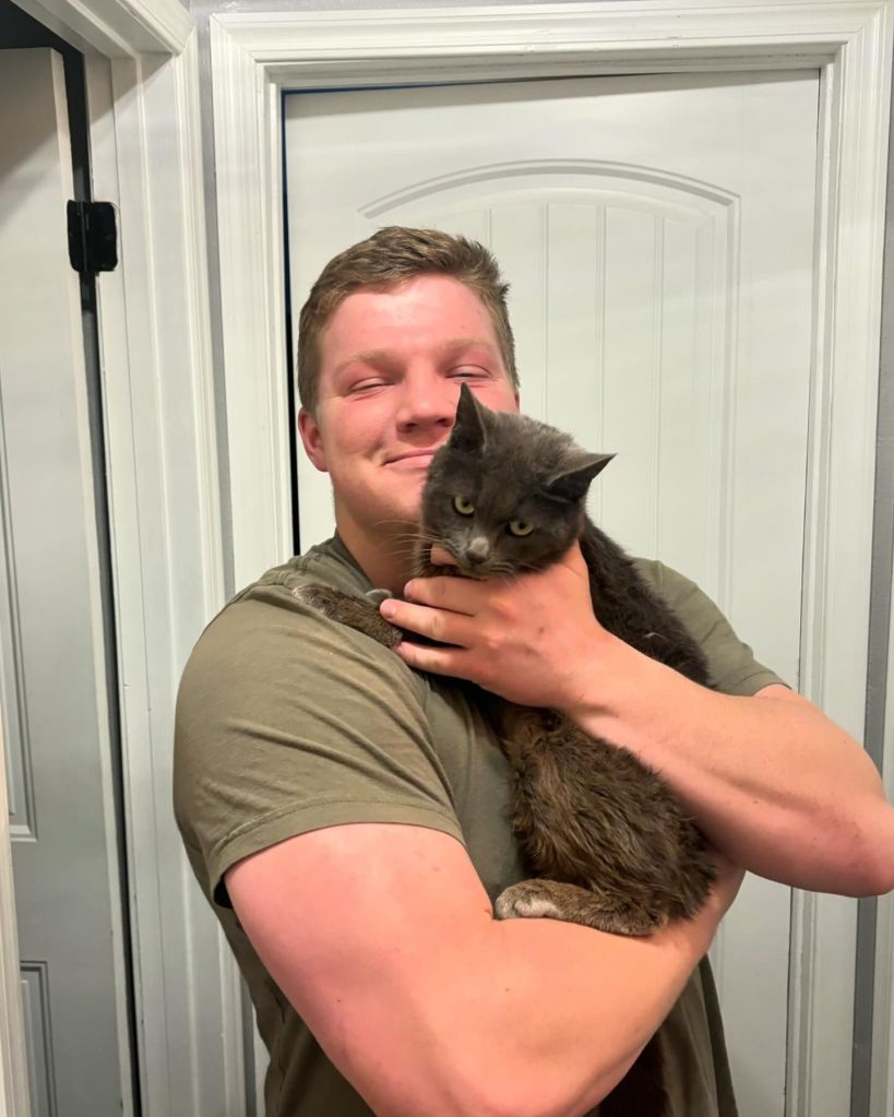 Garrison Brown smiling holding a cat. 