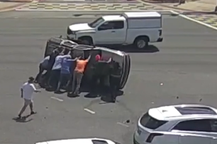 Eight strangers joined forces to rescue the occupants of an SUV that flipped on its side.